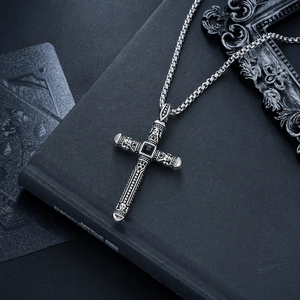 Détail du collier croix gothique vintage avec pierre noire et gravures de crânes