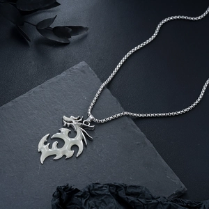 Macro shot of abstract dragon pendant with enamel inlay on textured slate stone surface