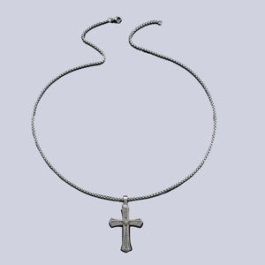 Collier élégant avec pendentif croix en strass brillants sur un fond violet pastel