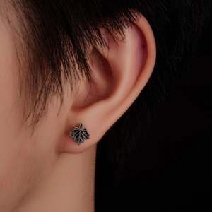 Detailed close-up of dark metal maple leaf stud earring with fine leaf vein texture