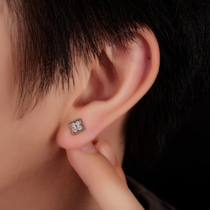 Minimalist silver four-leaf clover stud earrings with sparkling white zircons on ear