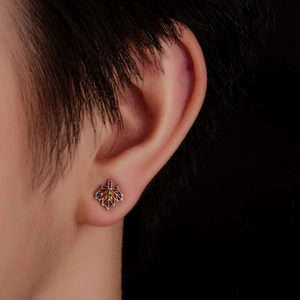 Macro shot of maple leaf stud earrings with vibrant red and orange gradient enamel