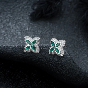 Macro view of clover stud earrings with green marquise stones and micro-pave white zircons