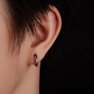 Close-up of minimalist silver hoop earring with pavé diamonds on model's ear
