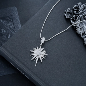 Macro shot of silver eight-pointed star pendant with zircons and snake chain