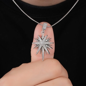Fashionable silver starburst pendant necklace with sparkling cubic zirconia on snake chain