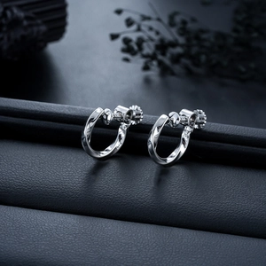 Gros plan de boucles d'oreilles Mobius en argent avec vis réglable sur cuir noir