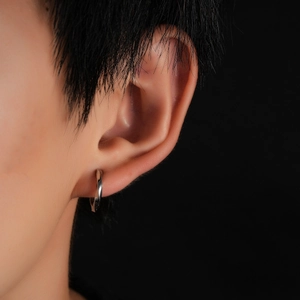 Gros plan d'une manchette d'oreille Mobius en argent poli sur un mannequin homme