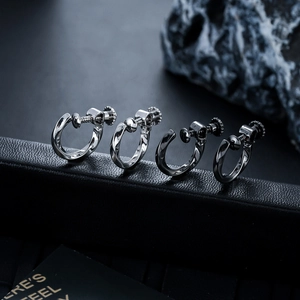 Détail de quatre clips d'oreilles Mobius argentés avec vis réglable sur base en cuir