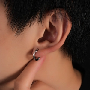 Gros plan d'un clip d'oreille Möbius en argent poli pour hommes sans oreilles percées