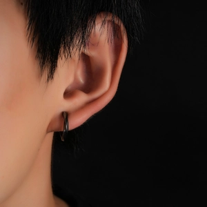Gros plan d'une boucle d'oreille à clip Mobius noire pour homme sur un mannequin
