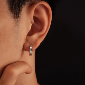 Orecchino a cerchio in argento stile gotico con incisione su modello uomo e sfondo nero