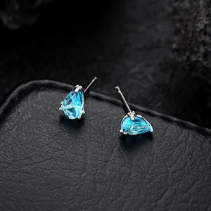 Elegant silver-toned pear-cut blue zircon stud earrings on a premium black leather texture