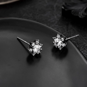 Macro view of micro-paved snowflake earrings with black plating and bright zircon