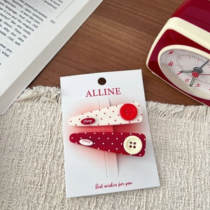 Close-up of retro polka dot hair clips with buttons on a brand display card