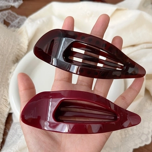 Close-up of hollow water drop hair clips in tortoiseshell brown and burgundy resin