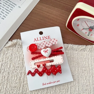 Detail of red and white polka dot bow hair clips and heart hairpins on display card