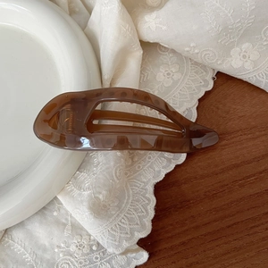 Detail of dark amber tortoiseshell hair claw clip with hollowed-out elegant design