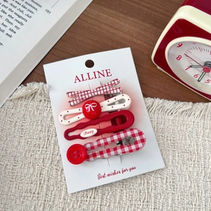 Detail of four-piece red and white hair clip set with bows and checkered patterns