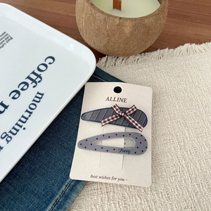 Detail of sweet duckbill hair clips with check pattern and Fancy text on display card