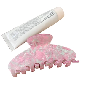 Pince à cheveux en acétate avec motif de marbre rose et blanc pour femmes sur fond blanc