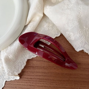 Elegant 11.5cm hollow burgundy hair claw clip for women on a rustic wooden table