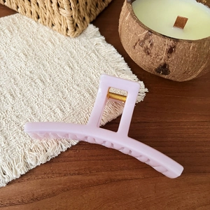 Close-up of a matte light pink French hair claw clip with a durable gold metal spring detail