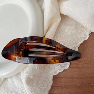 Close-up of 11.5cm amber resin leaf hair claw with elegant hollow texture details