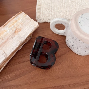 Détail de la pince à cheveux élégante de 7 cm en lettre B avec texture écaille foncée