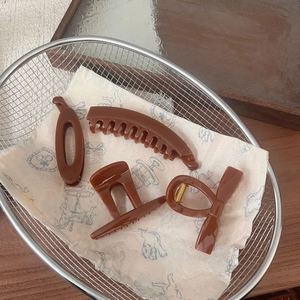Set of four dark brown hair clips including banana and pumpkin claw styles in a silver basket