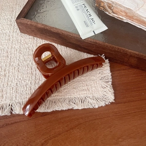 Detail view of sunset orange large claw clip with a high-gloss finish and metal spring