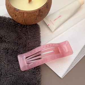 Detail of pink translucent resin rectangular hair claw clip with cutout design