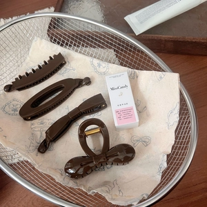 Elegant dark brown hair clip set and MissCandy nail polish in a minimalist wooden tray