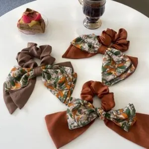 Three-piece set of caramel and brown pleated scrunchies with satin bow details