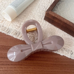 Detailed side view of an elegant mauve butterfly hair claw clip with golden spring
