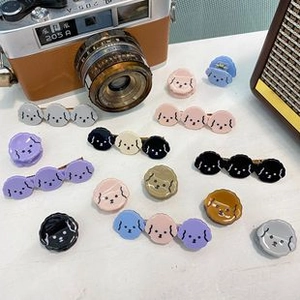 Detail shot of cute poodle hair clips in Morandi colors with a vintage camera backdrop
