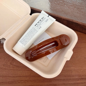 Gift set featuring a peach rose hand cream and a dark brown hollow hair claw clip