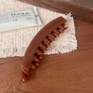 Detail of elegant sunset orange hollow pumpkin claw clip with glossy finish and secure grip