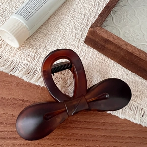 Detail of 10.5cm dark brown tortoiseshell hair claw clip with elegant bow design
