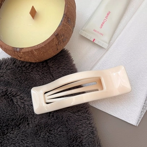 Minimalist cream rectangular hair claw clip for women on a cozy lifestyle background