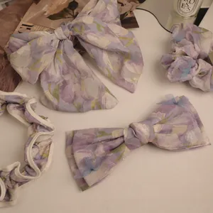 Detail of a 4-piece set of purple floral hair accessories with tulip print fabric