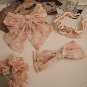 Detail of four-piece floral organza hair accessory set with tulip pattern on a white desk