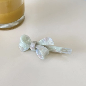 Barrette nœud élégante en acétate violet étoilé avec logo doré pour coiffure latérale