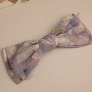 Detailed shot of floral print bow hair accessory with translucent mesh butterflies