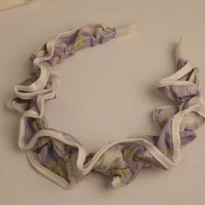 Detail of floral chiffon headband with purple print and white ruffled edges