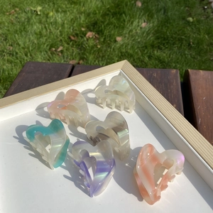 Detail of colorful heart-shaped acetate hair claws with marble texture in a 6-piece set