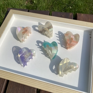 Set of 6 colorful heart-shaped acetate claw clips with a pearlescent finish in a tray