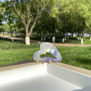Detail view of heart-shaped iridescent acetate hair claw clip with colorful pearly finish