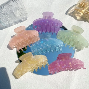 Set of six large iridescent acrylic hair claws in vibrant jelly candy colors on mirror