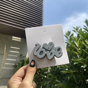 Detail of grey Y2K acetate hair clip with LOVE lettering and small rhinestone heart
